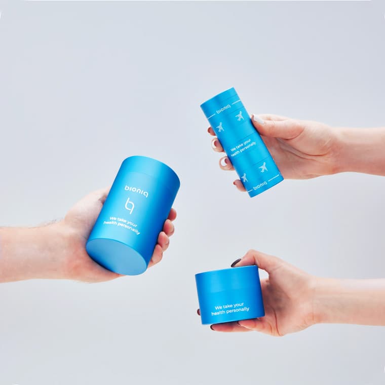 Hand holding a phone showing the Bioniq app with wellness goals